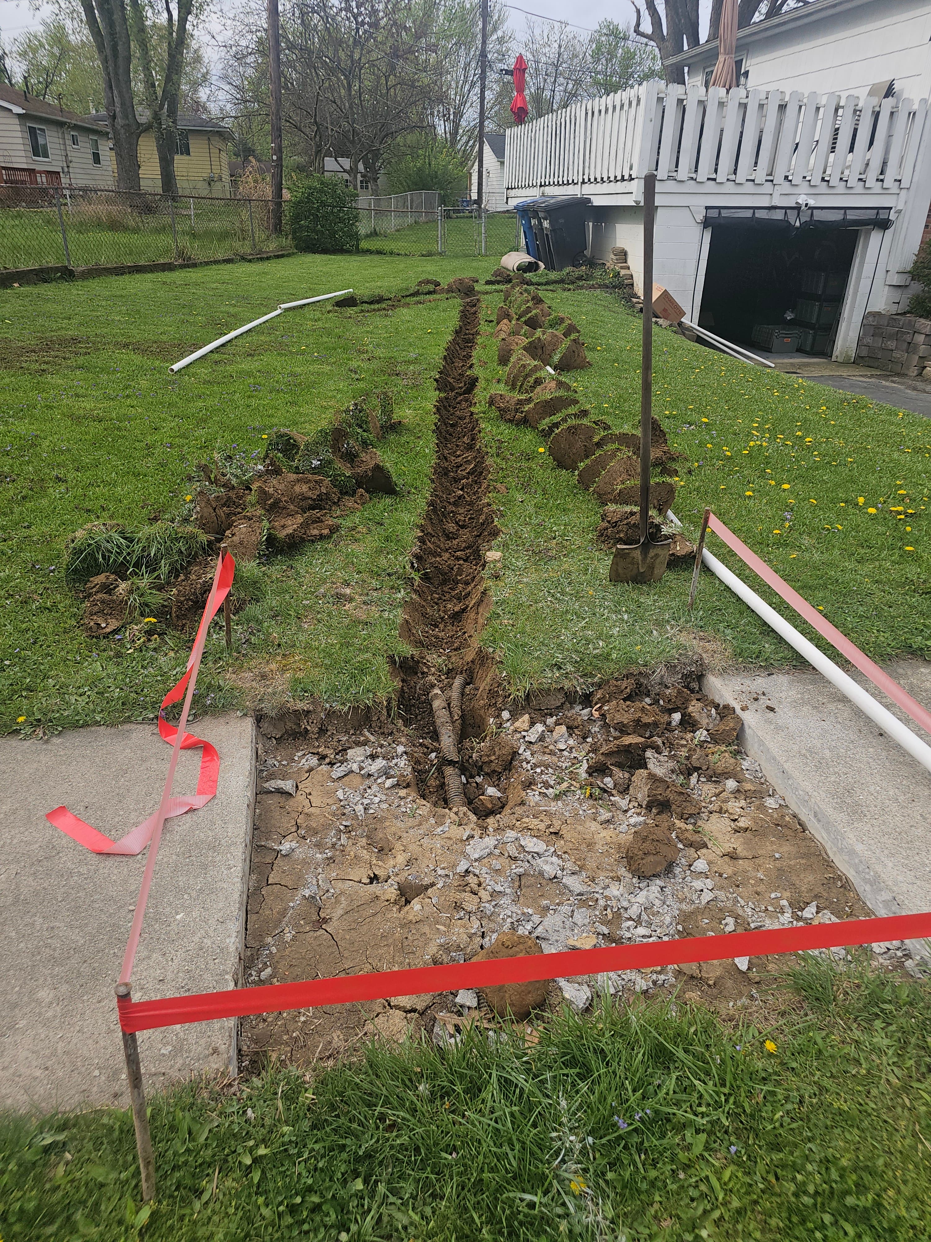 Trench dug across a Central Ohio yard for sump pump discharge line installation