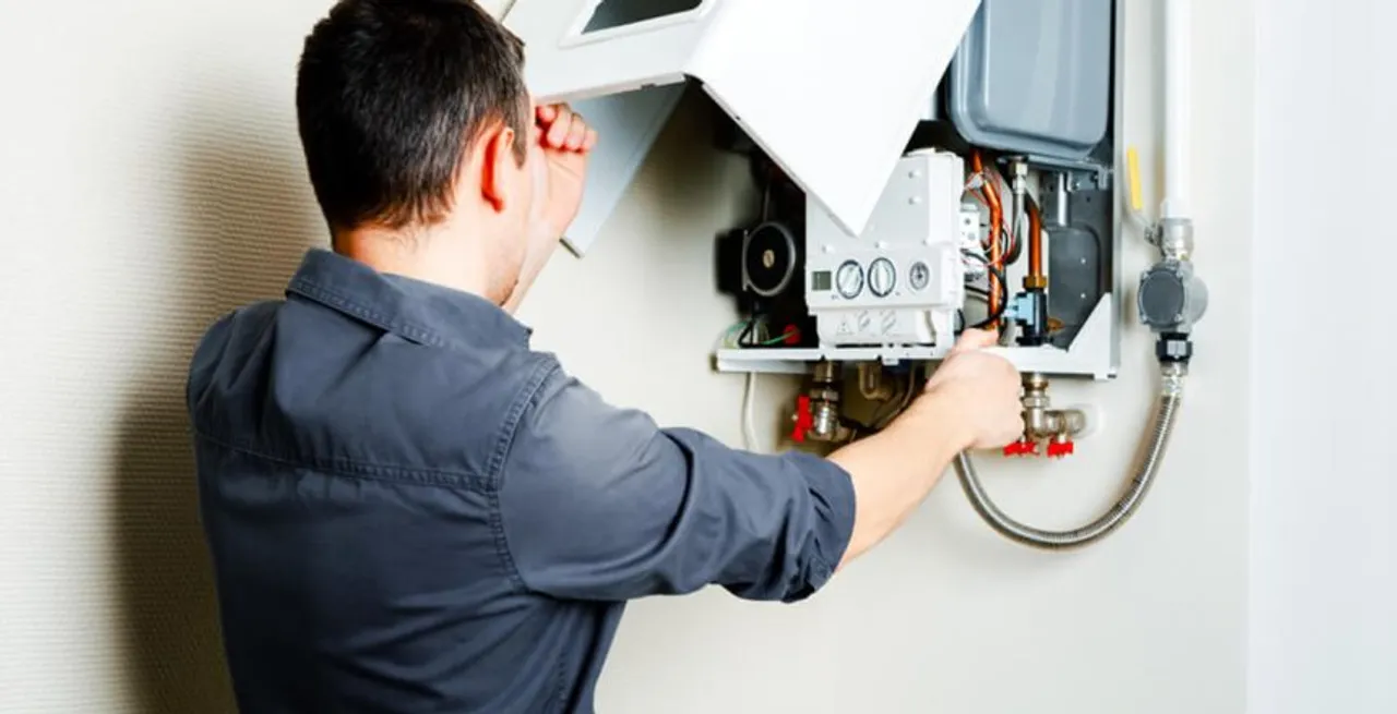 Technician performing water heater flush and maintenance service