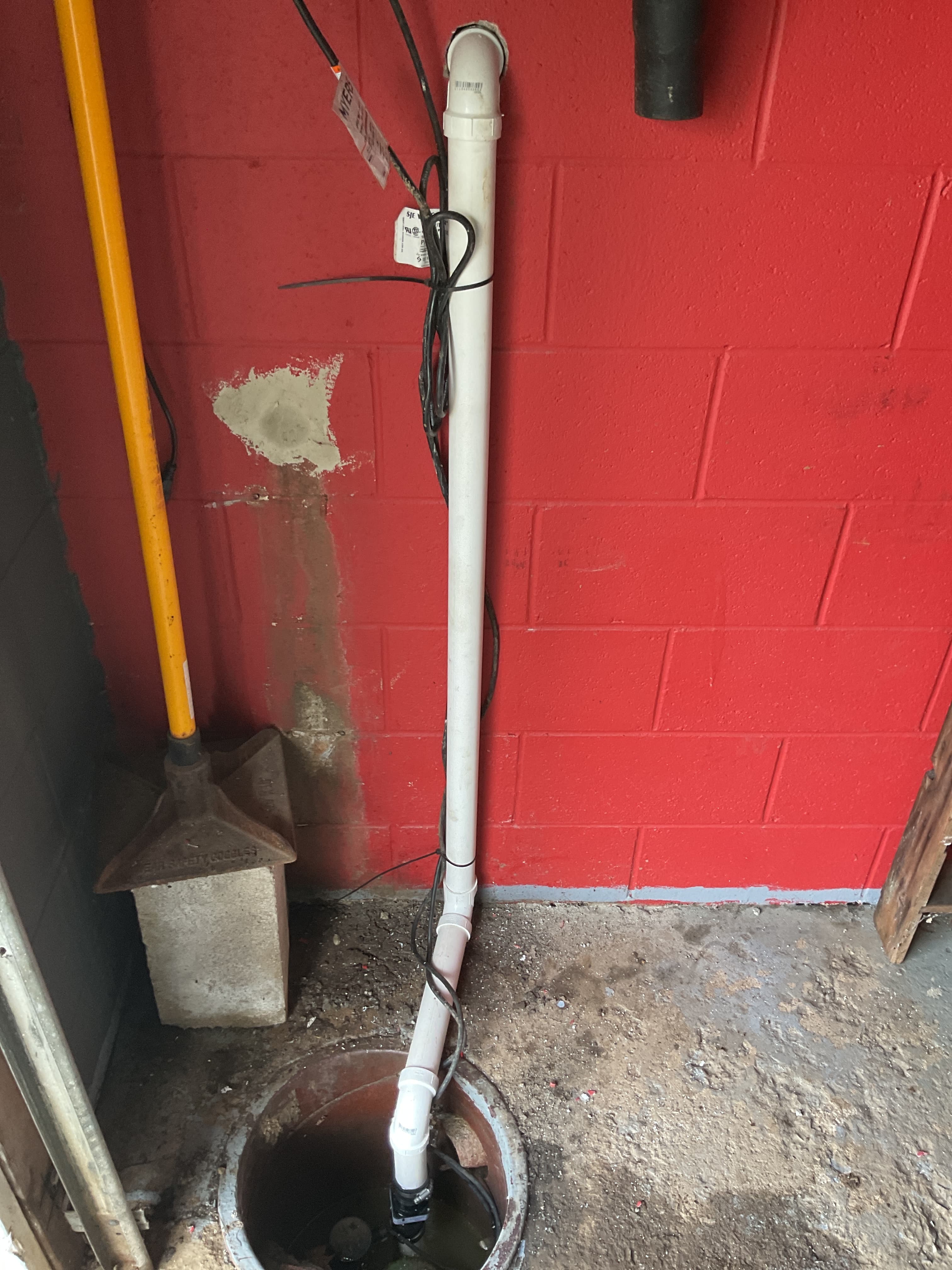 Completed sump pump and PVC discharge line installation by Allegiant Plumbing